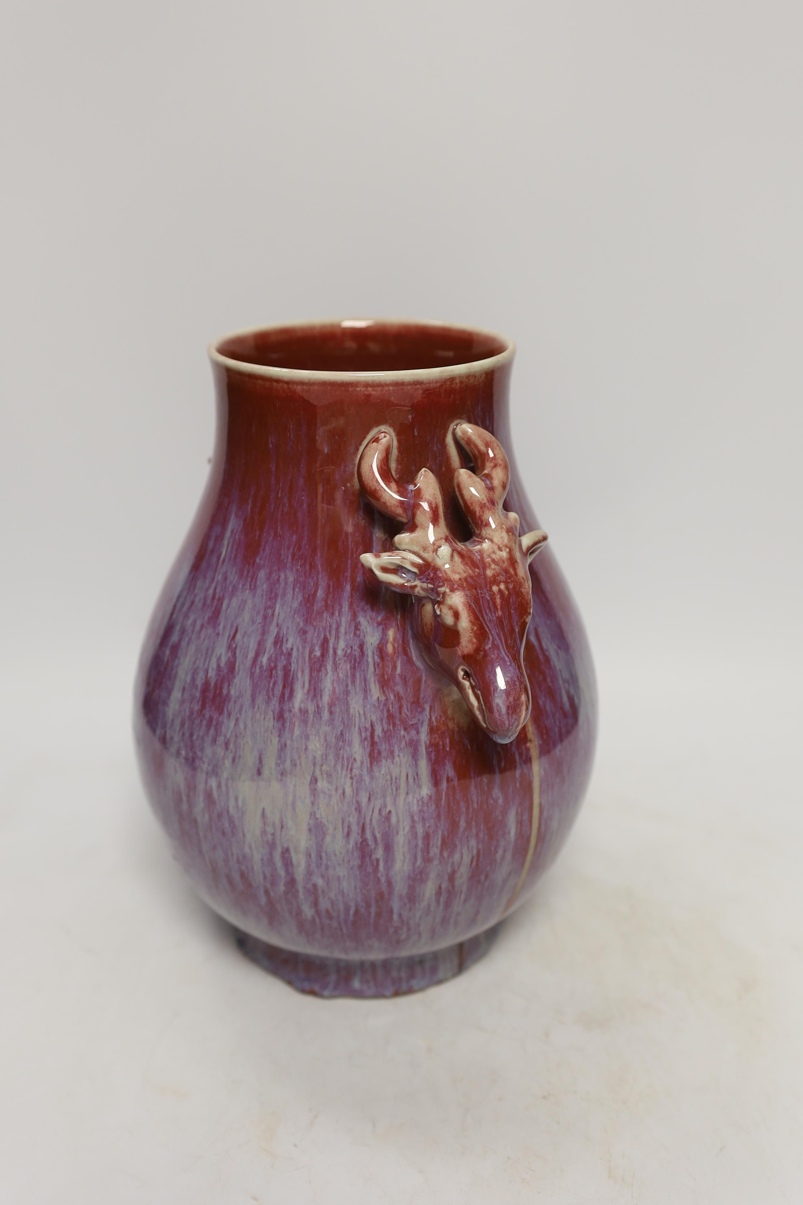 A Chinese sang de boeuf vase, stag head handles, 26cm